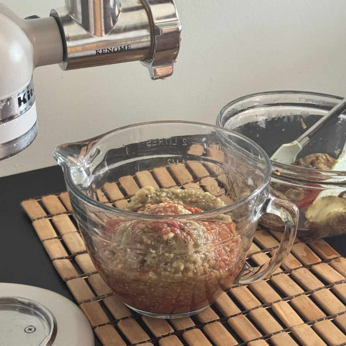 Grinding the roasted vegetables with a meat grinder.