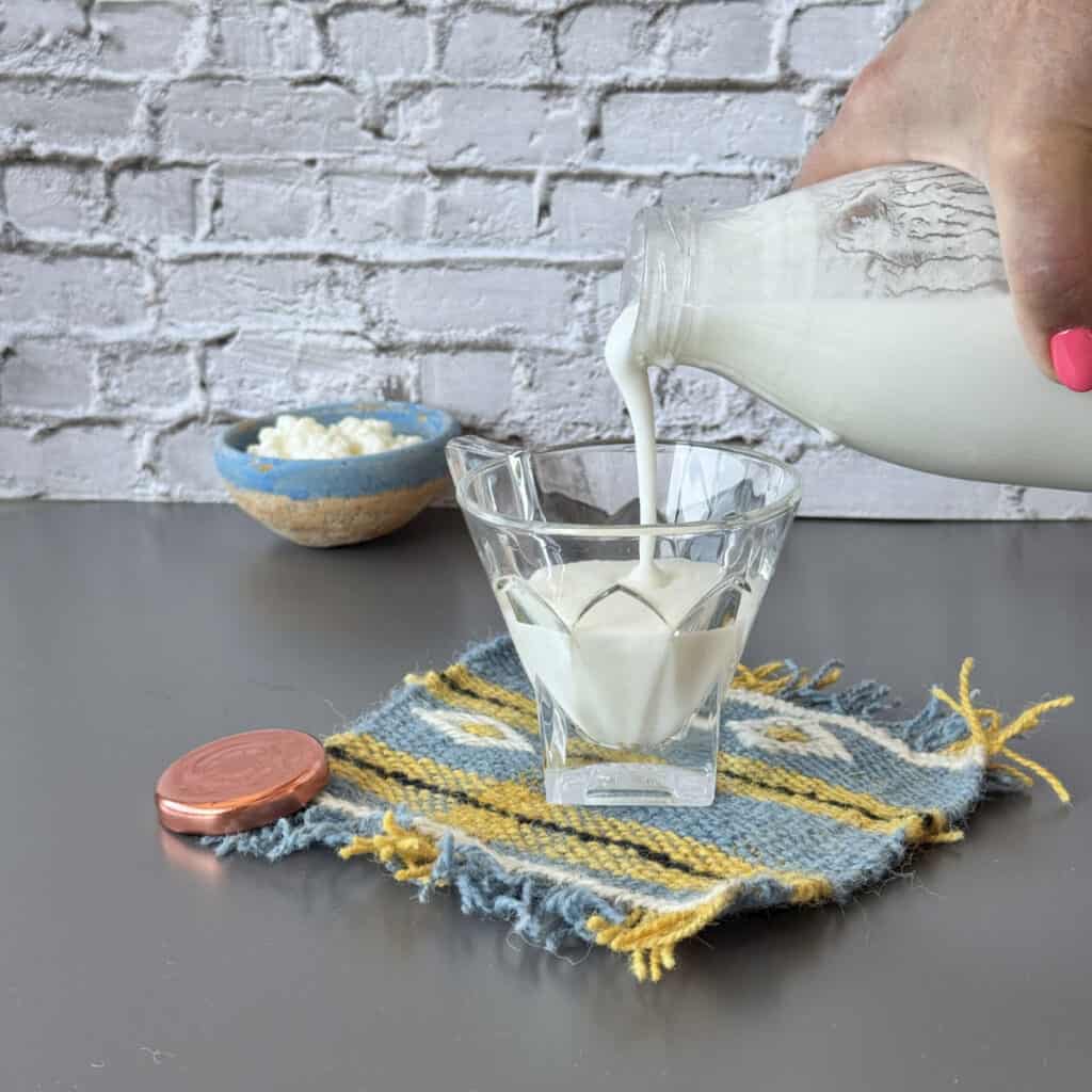 Pouring kefir into a glass.