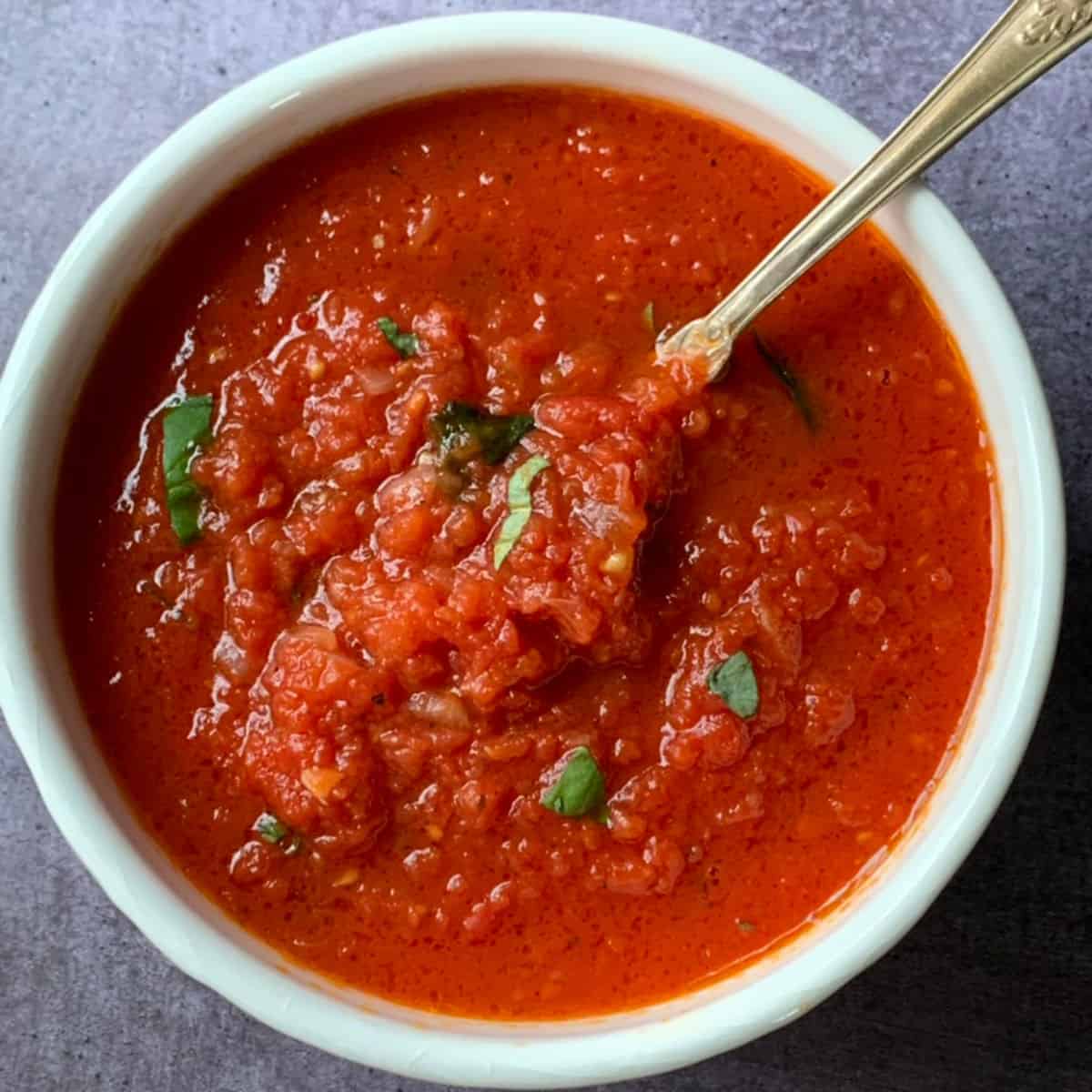 Tomato sauce in a bowl with a spoon.