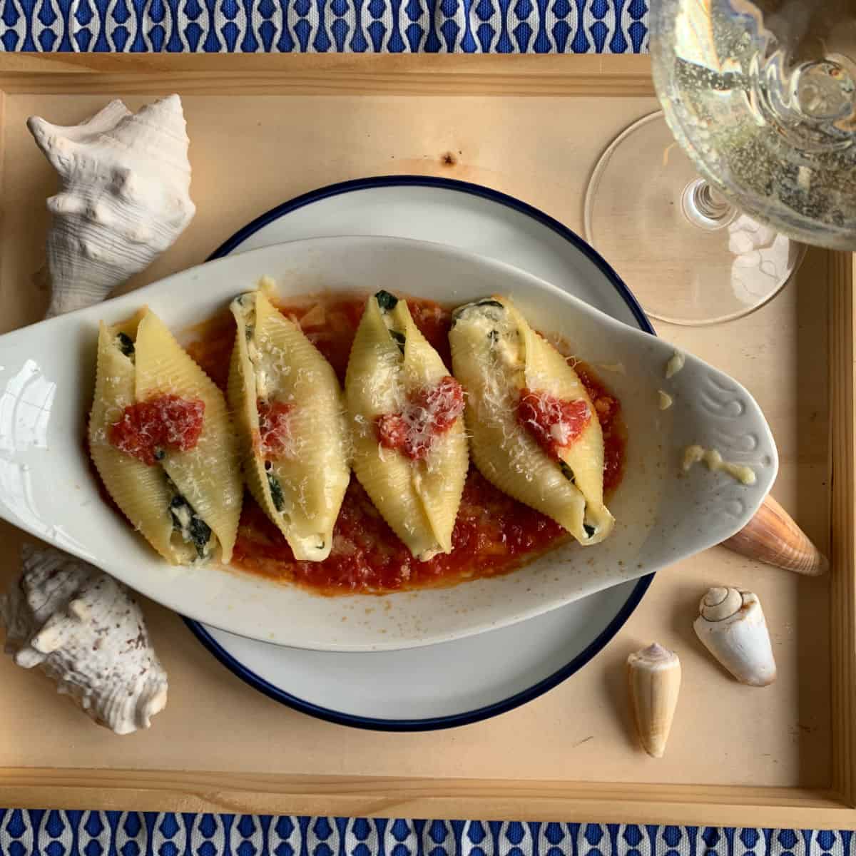 Serving baked shells on a tray with glass of wine.