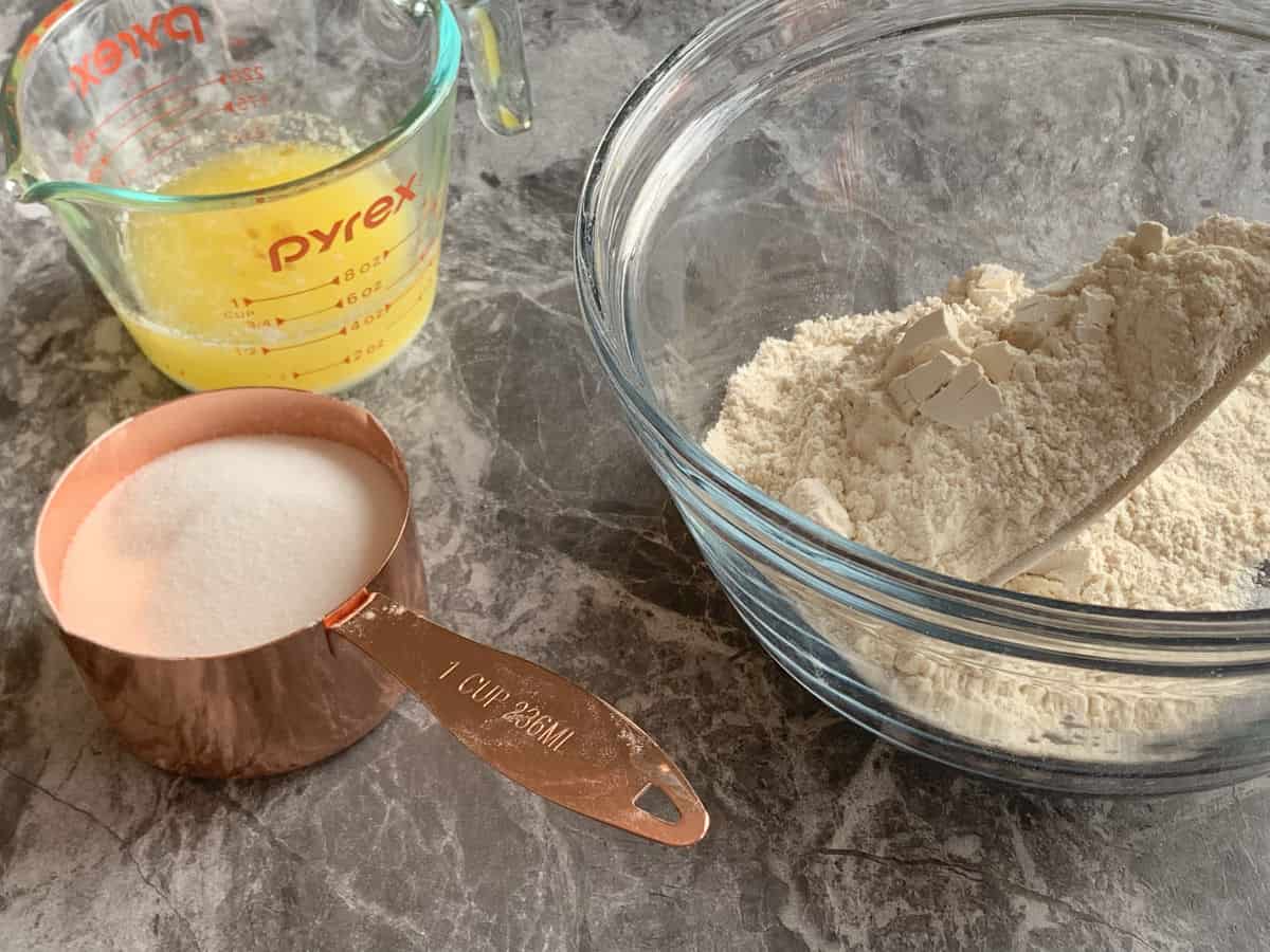 Sugar, flour, and melted butter on a counter. 