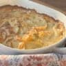Baked potato au gratin in a white baking dish.