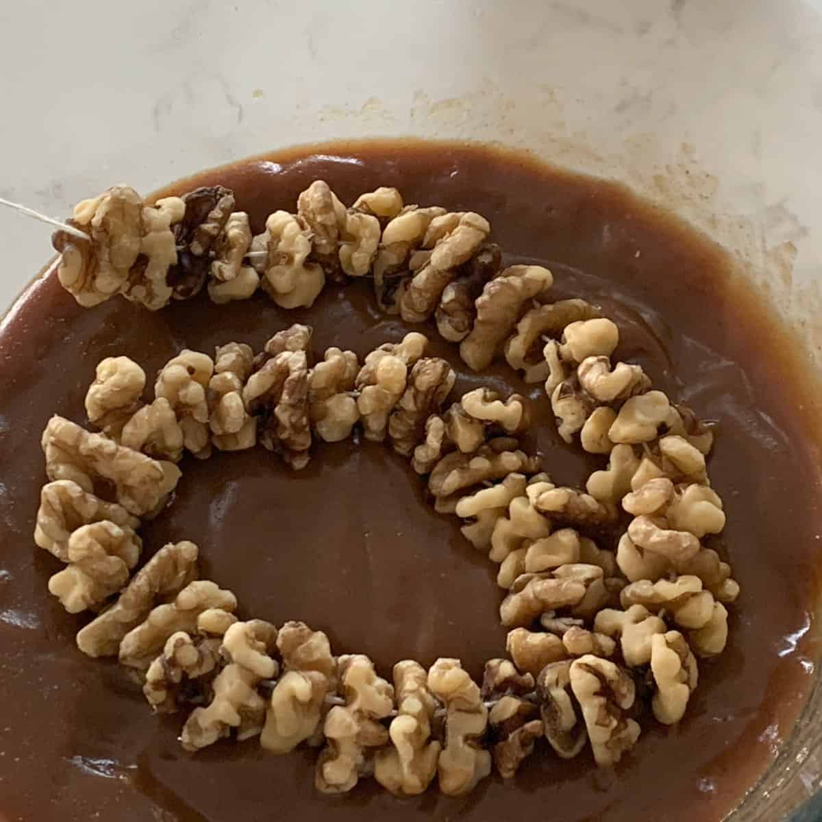 Dipping walnut string in shpot.