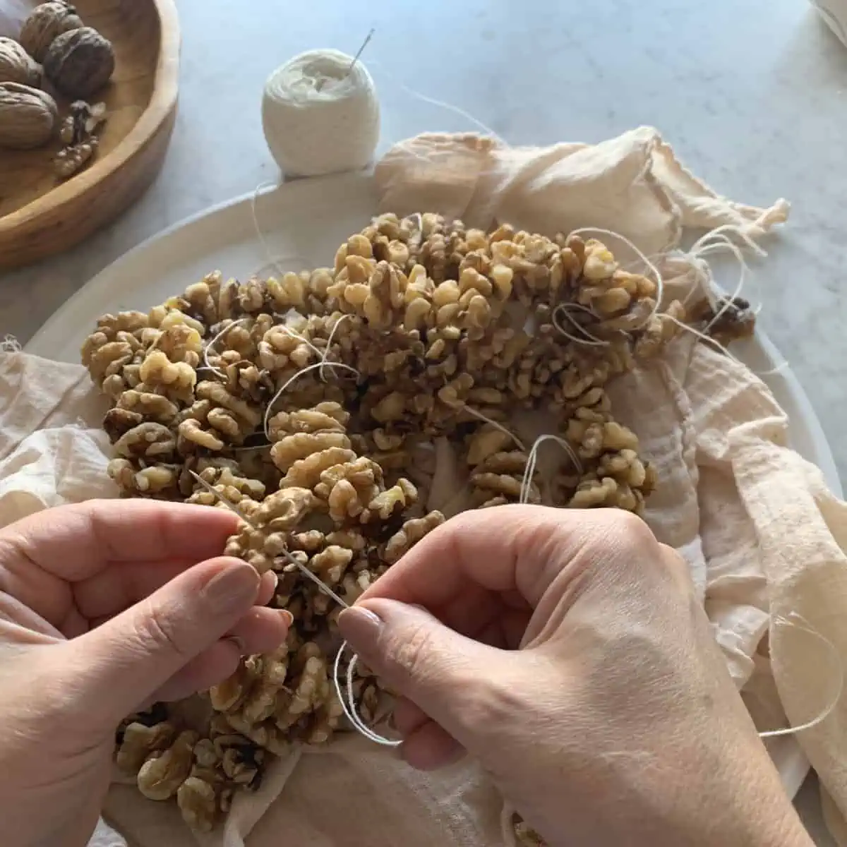 Stringing the walnuts with tread and needle.
