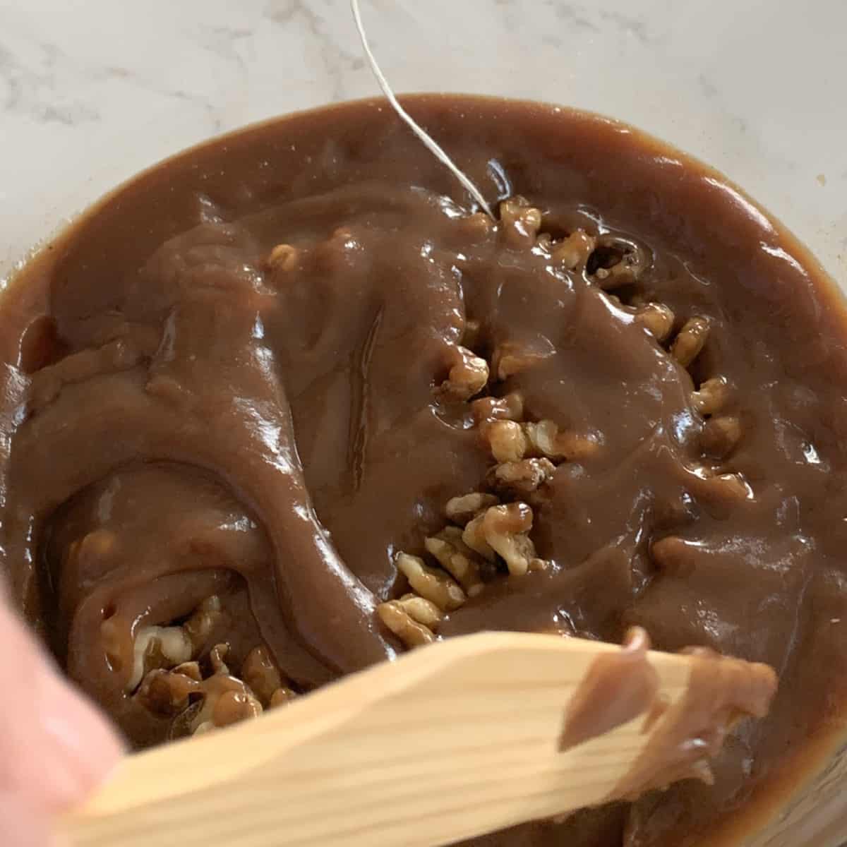 Submerging walnut string in shpot.