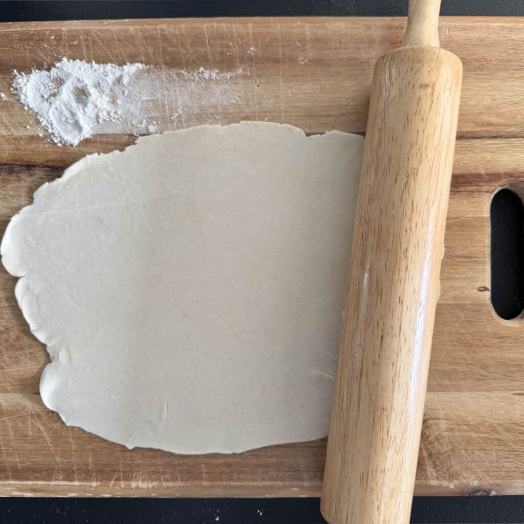 Rolling the dough on a wooden board.