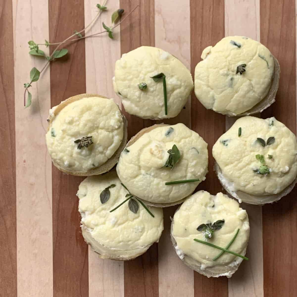 Goat cheese stuffed artichoke bottoms on a cutting board.