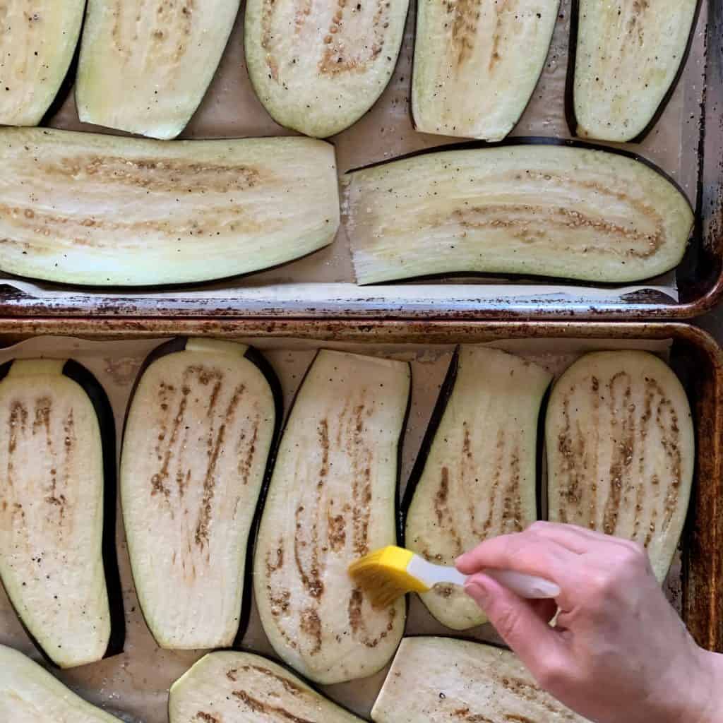 Involtini di Melanzane - Eggplant Rollatini brushing oil on slices.