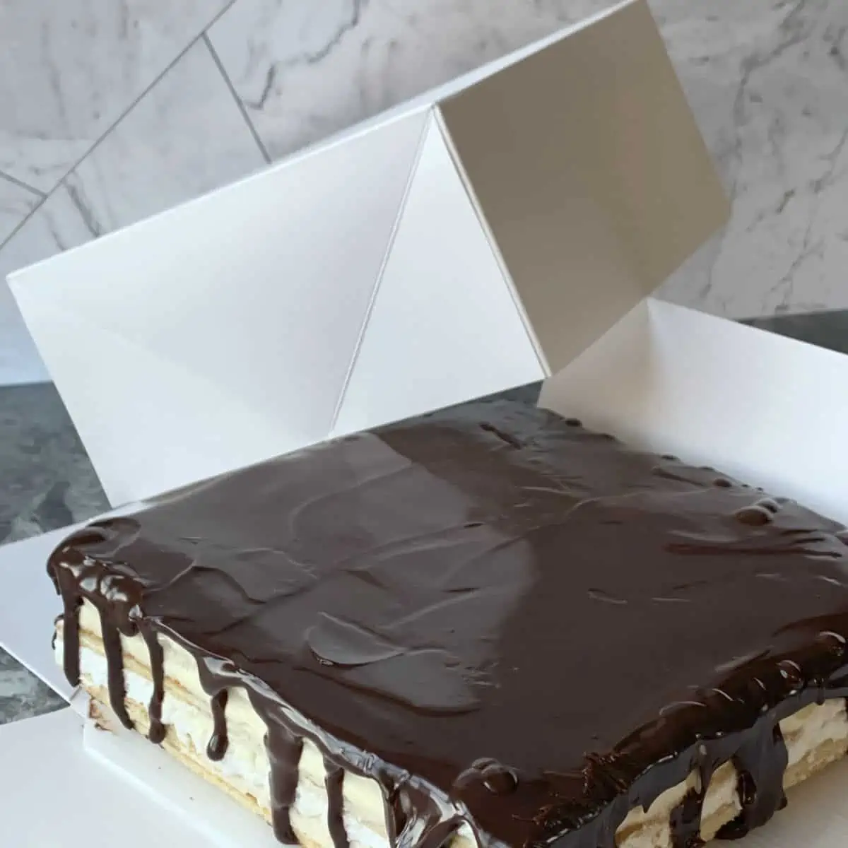 Birds milk cake in a cake box.