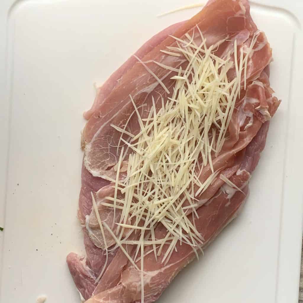 Adding grated Parmesan cheese.