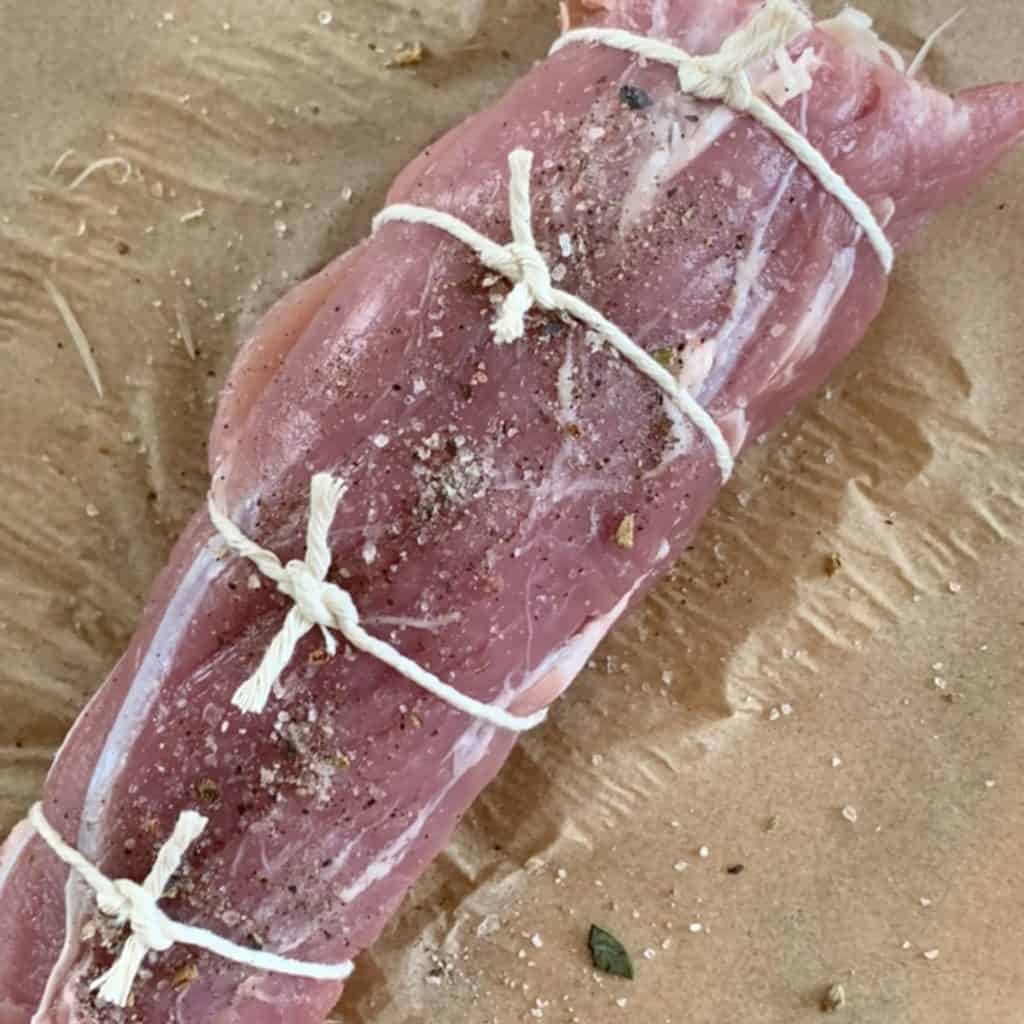 Trussing the meat with the kitchen twine.