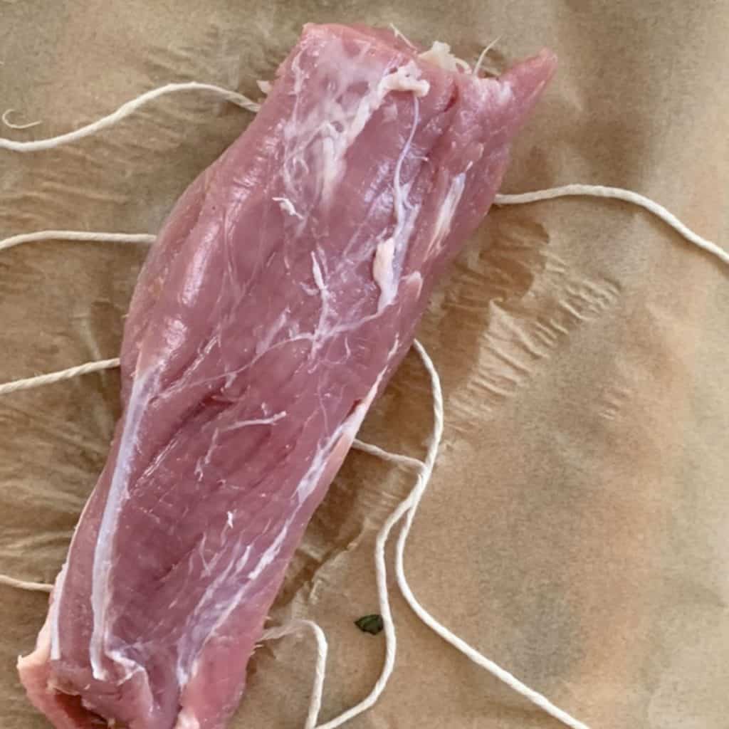 Trussing the meat with the kitchen twine.