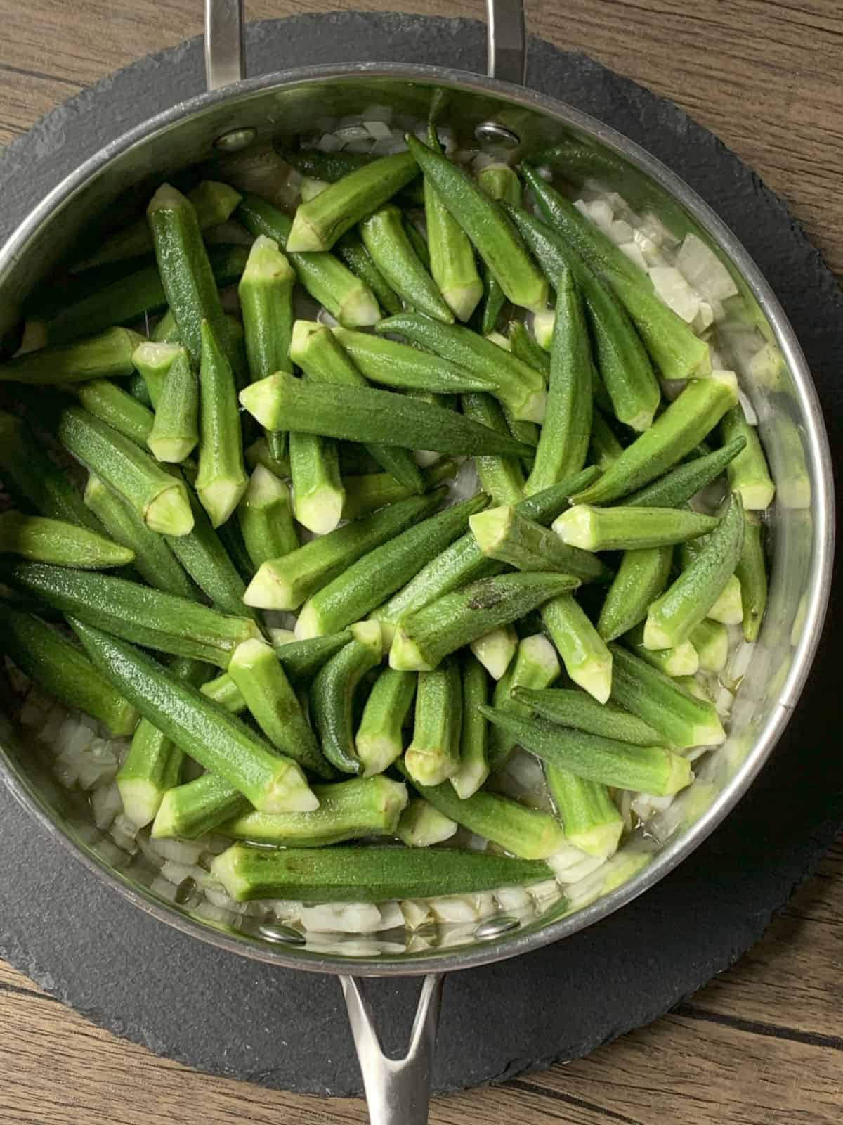Okra added to the sauté pan.