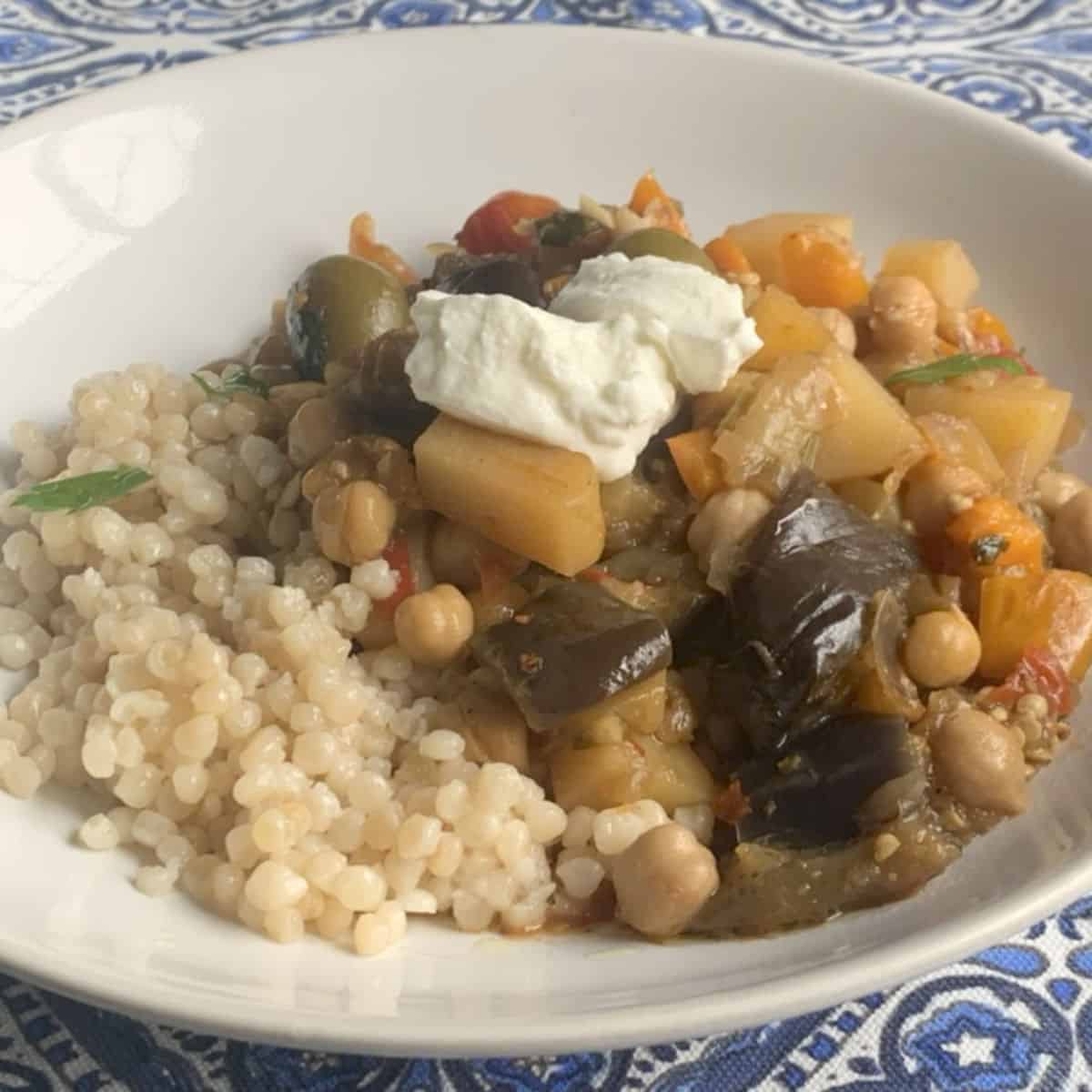 Chickpea eggplant tajine with pearl couscous and dollop of Greek yogurt.