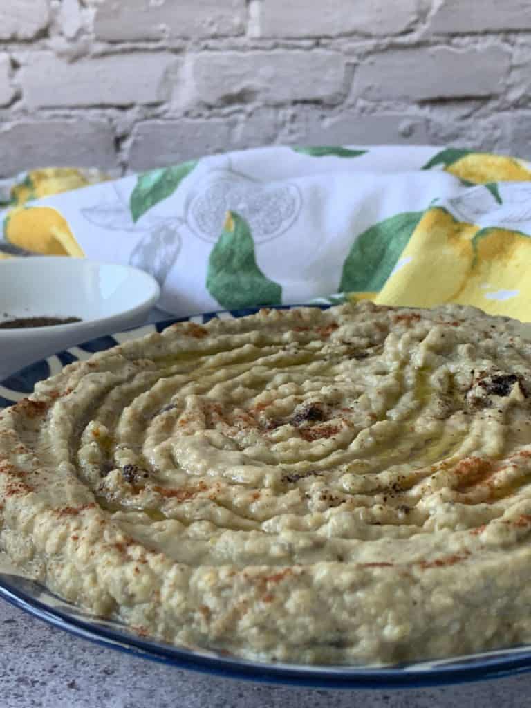 Mutabal Roasted Eggplant Dip in a plate and towel behind.