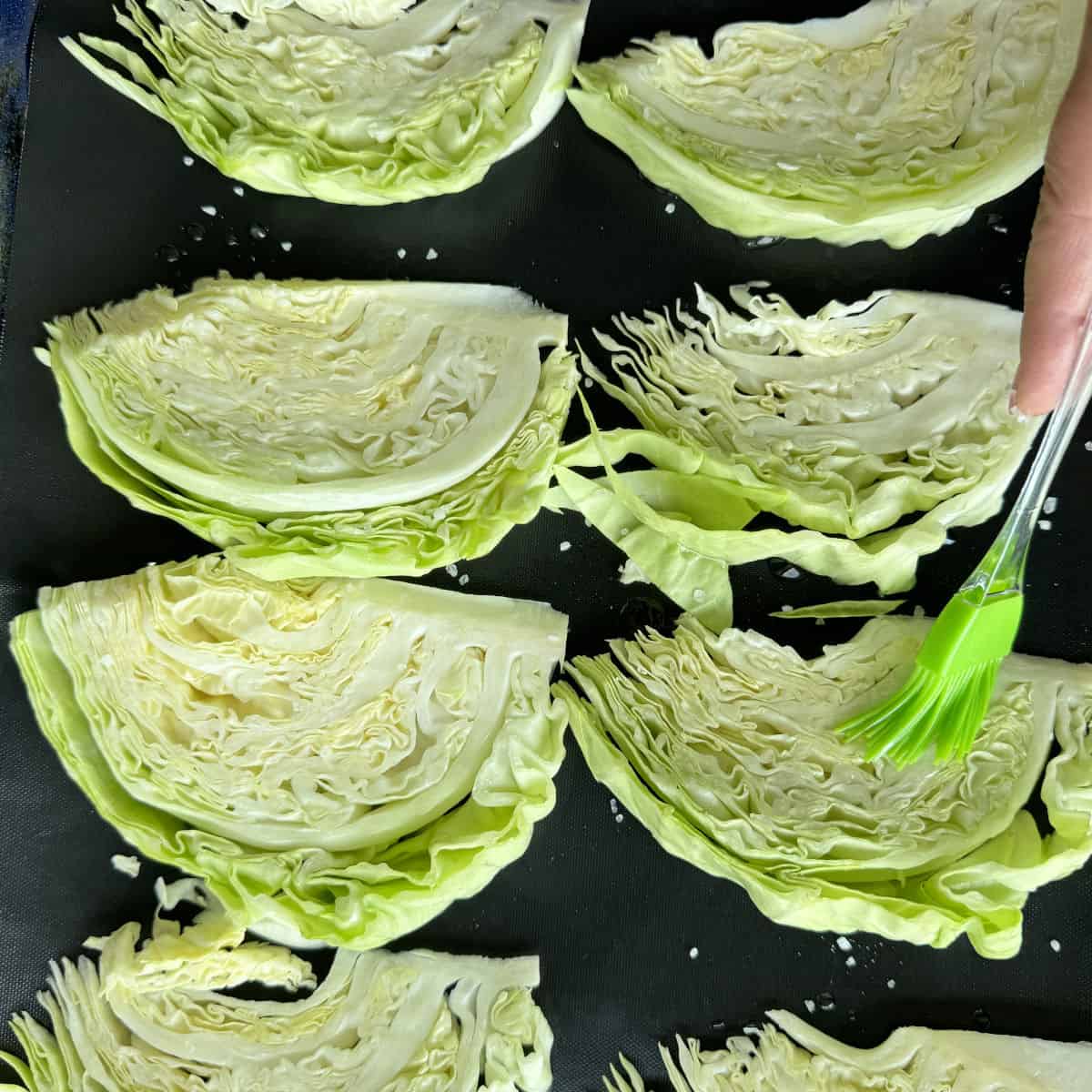 Brushing oil on the cut cabbage.