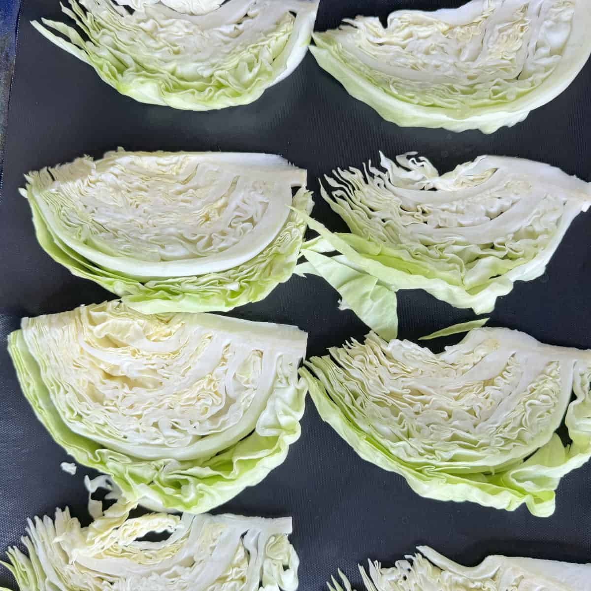 Cut cabbage wedges on a sheet pan.