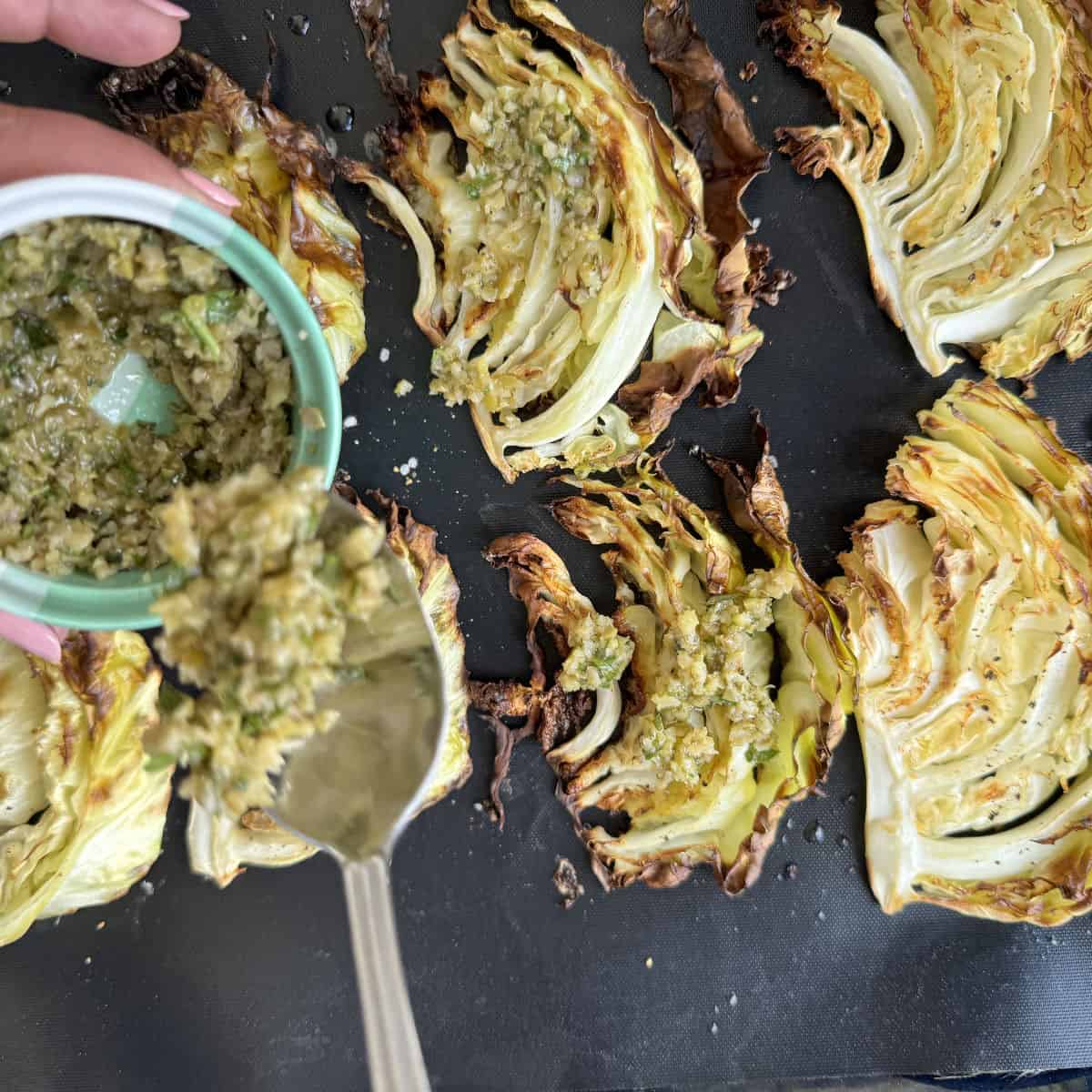 Spooning the tapenade on to the roasted cabbage.