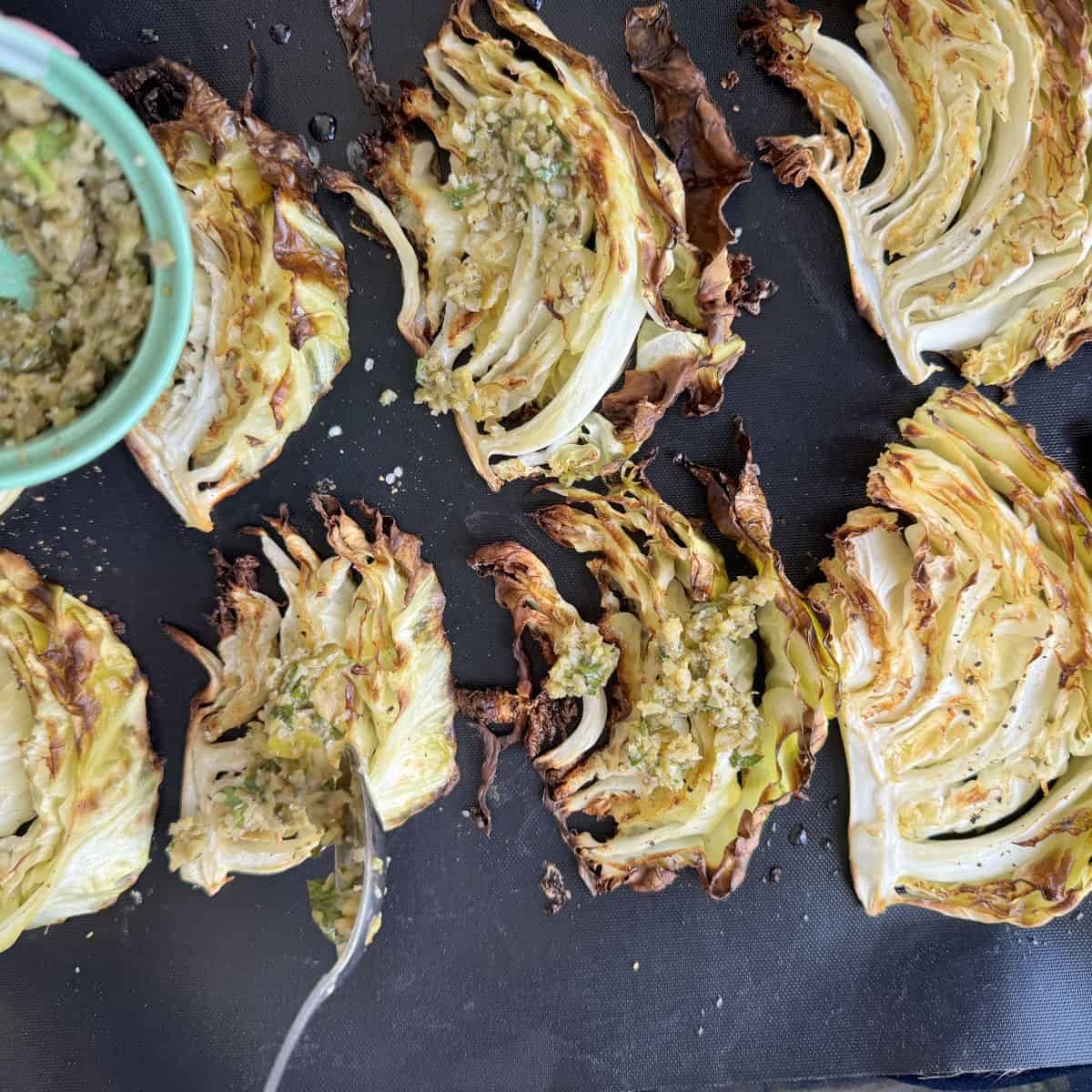 Spooning the tapenade on to the roasted cabbage.