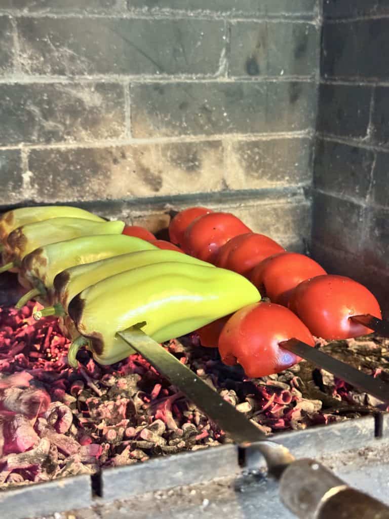 Roasting peppers and tomatoes on charcoal.