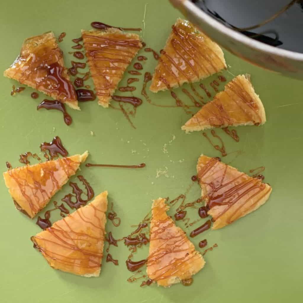 Drizzling caramel on a cake layer wedges.