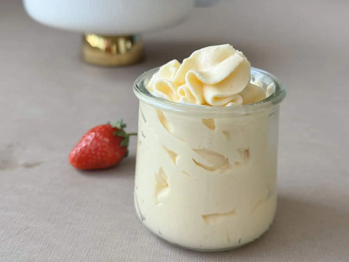A Cream Mousseline in a jar and a bowl of strawberries.