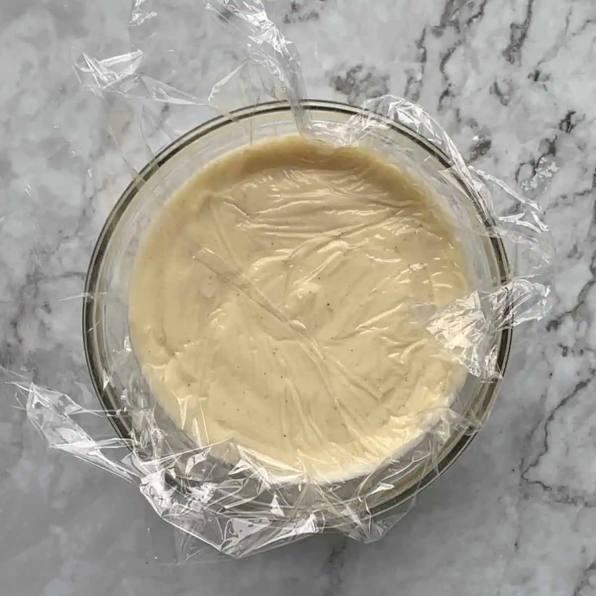 Pastry cream covered with plastic wrap.