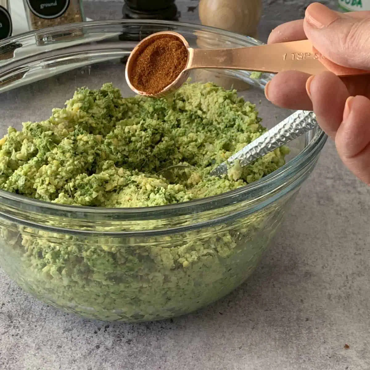 Adding paprika to falafel mixture.