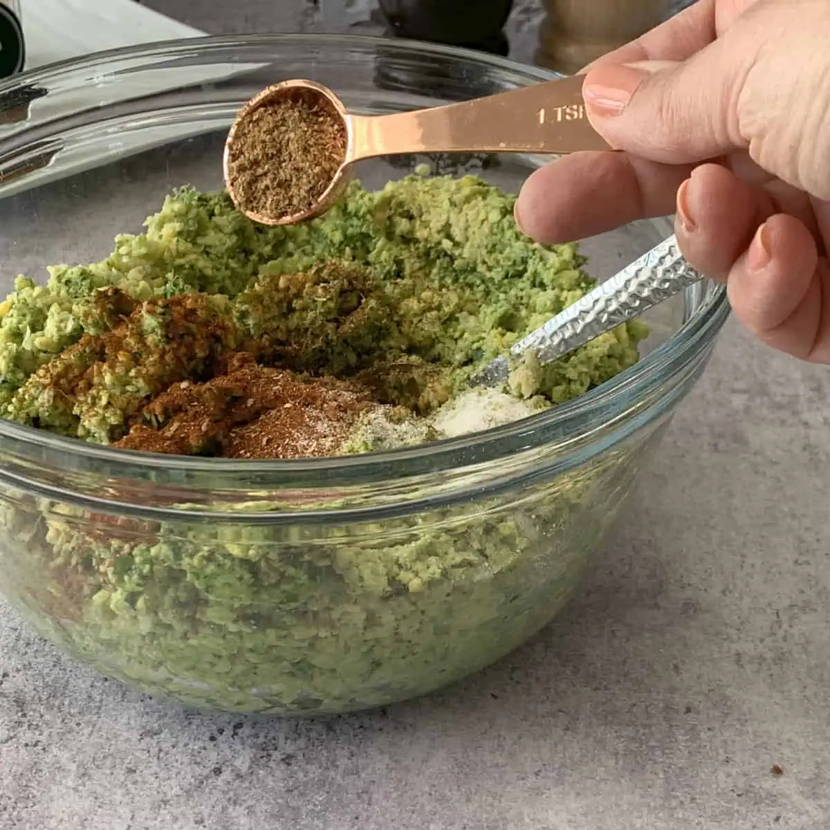 Adding coriander seeds to falafel mixture.