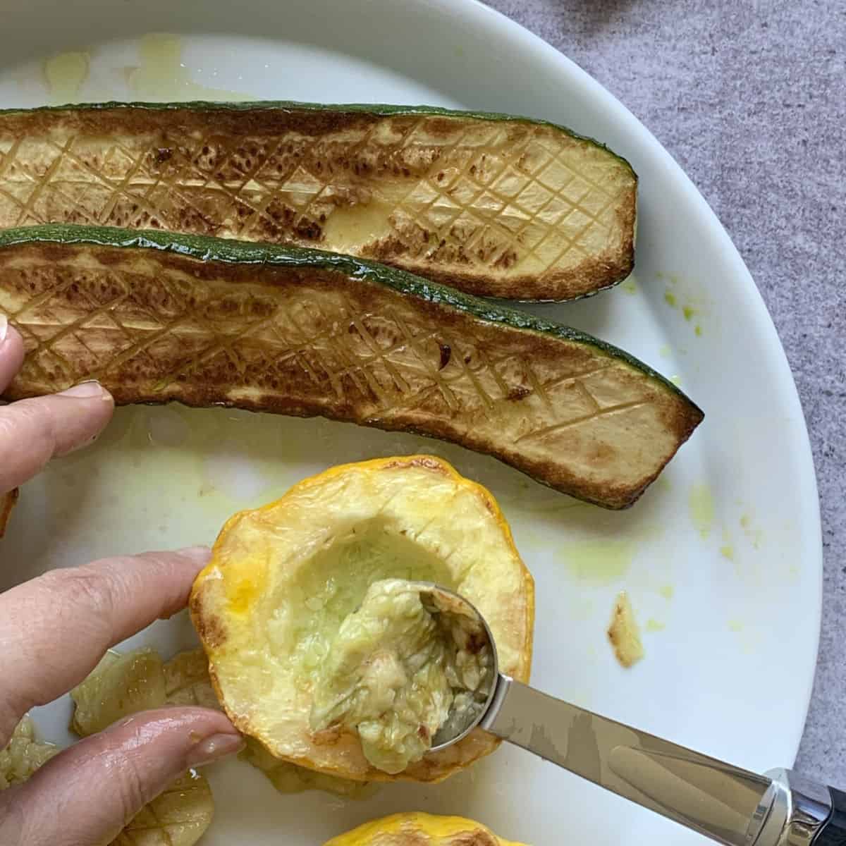 Scooping out pattypan zucchini.