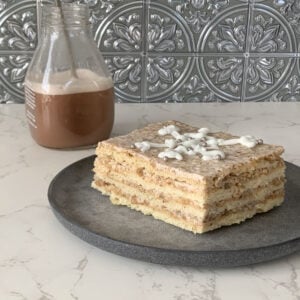 Slice of cake with chocolate milk in the background.