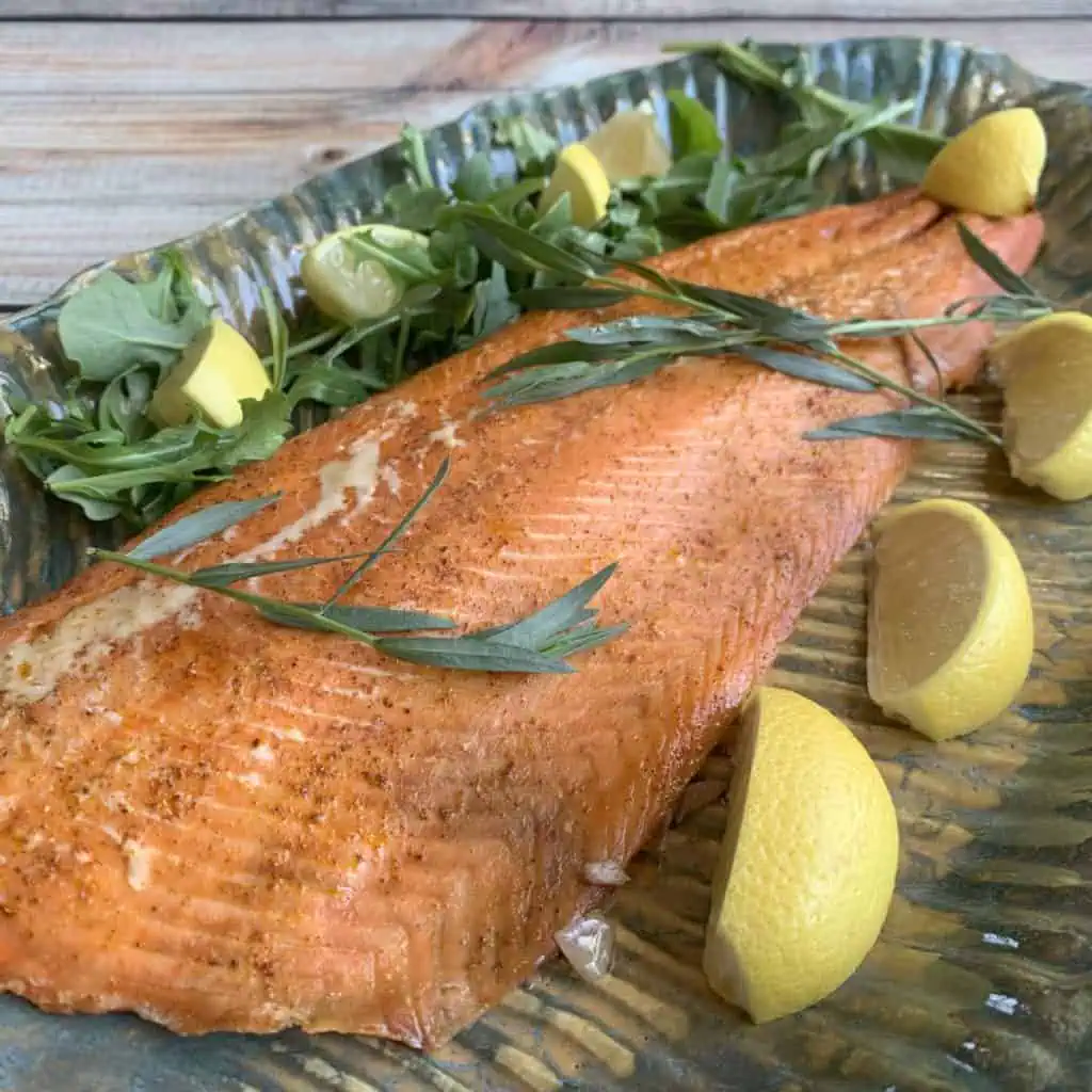 Smoked salmon with lemon wedges and tarragon.