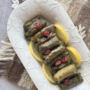 Rice tolma on a white platter over the carpet.