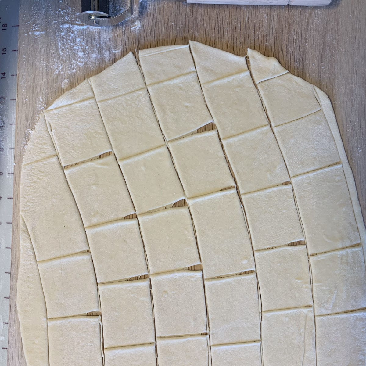 Cutting the dough with the ravioli cutter.