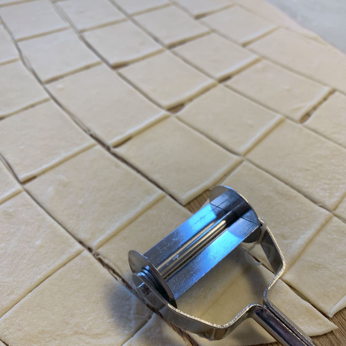 Cutting the dough with the ravioli cutter.