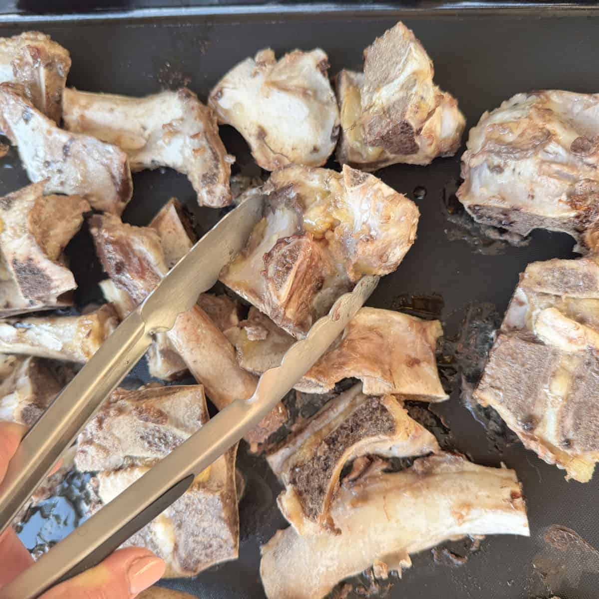 Flipping the bones with a tongs.