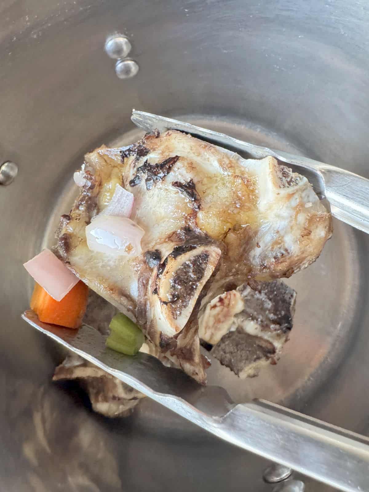 Transferring bone to a stock pot.