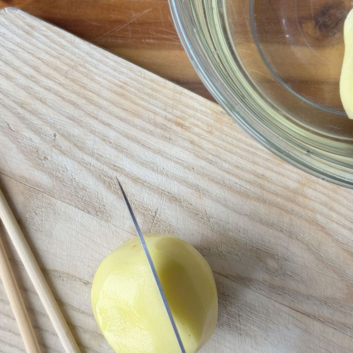 Hasselback potato process shots, cutting potato in half.