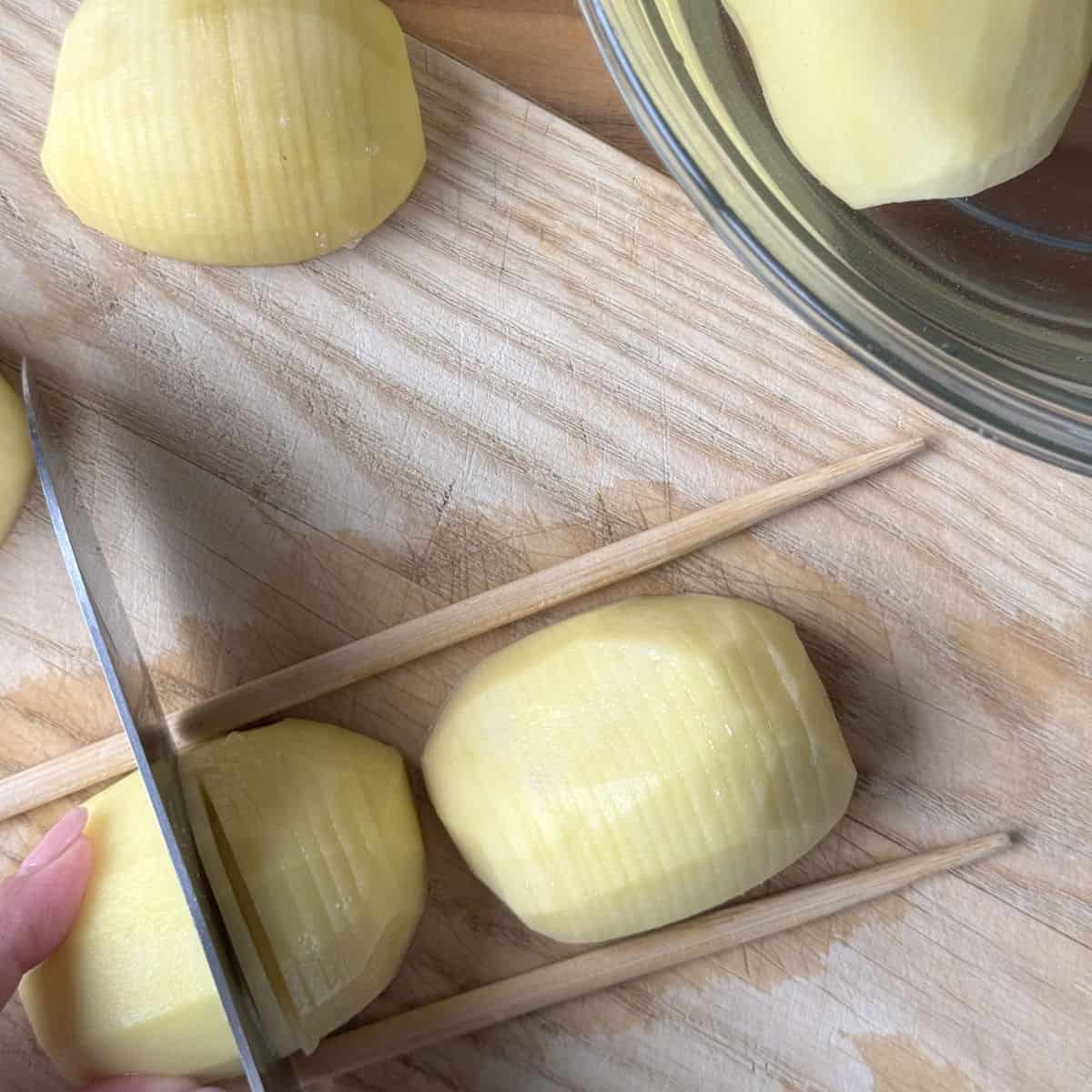 Hasselback potato process shots, scoring the potato halves.