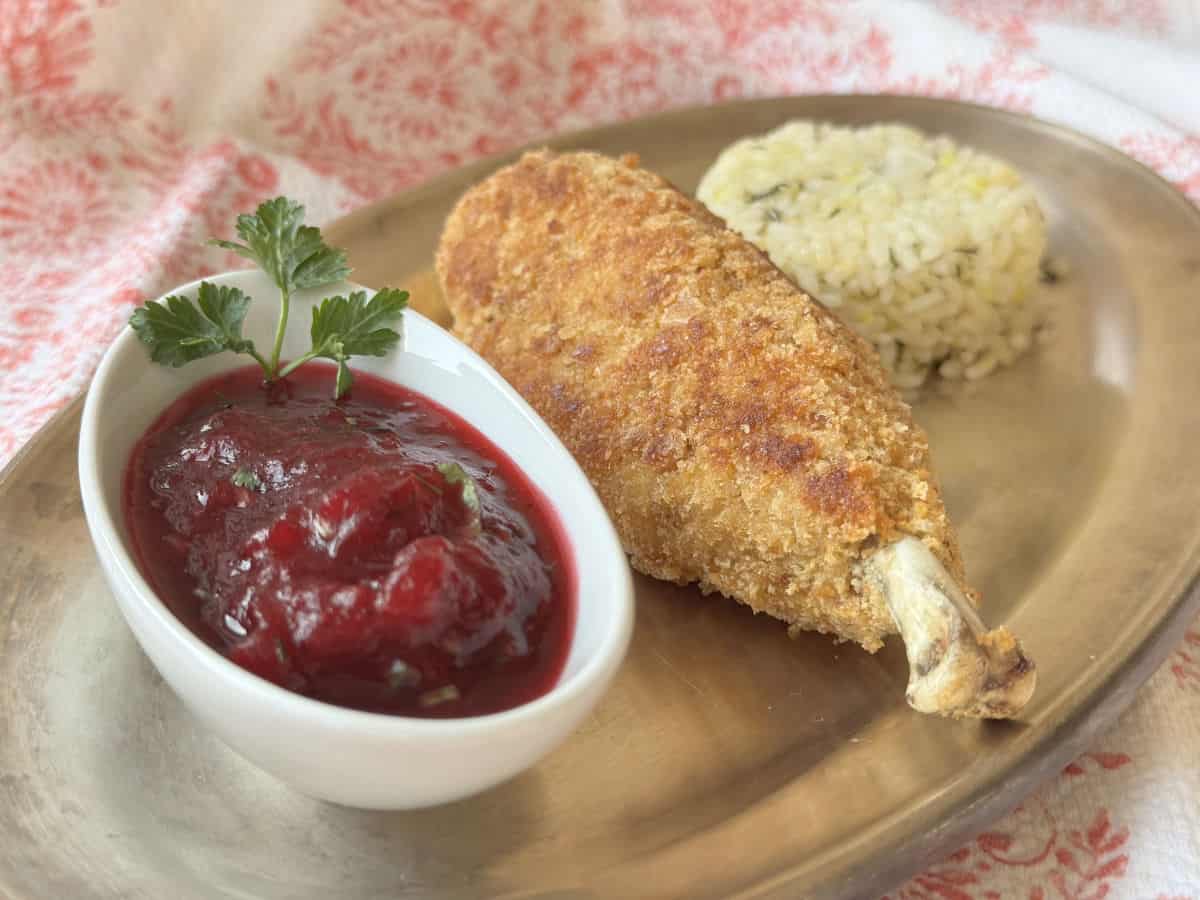 Chicken Kiev kotlet with a bed of rice and cranberry sauce.