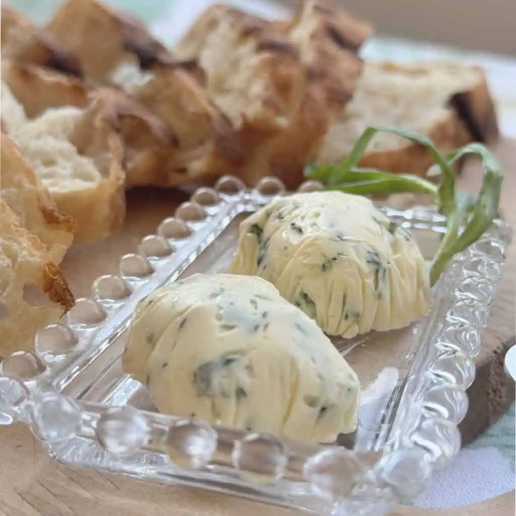 A close-up of a tarragon compound butter with slices of bread.