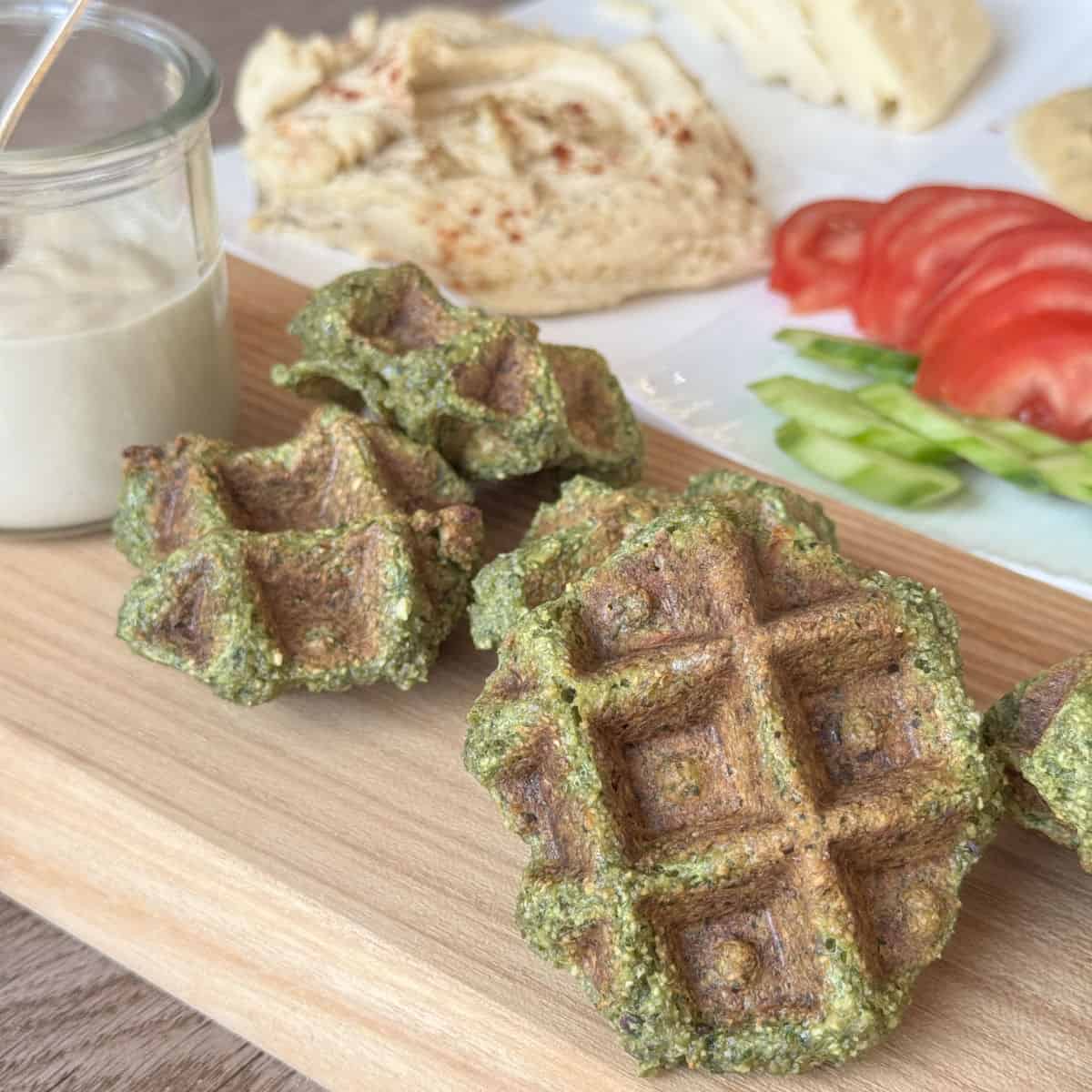 A close-up of falafel waffle on a wooden board.