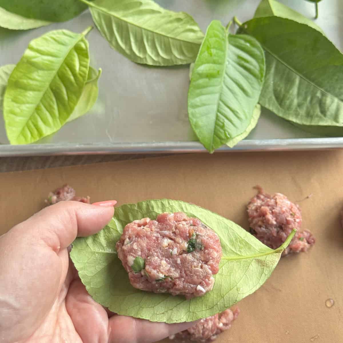 A meatball is placed on a lemon leave.