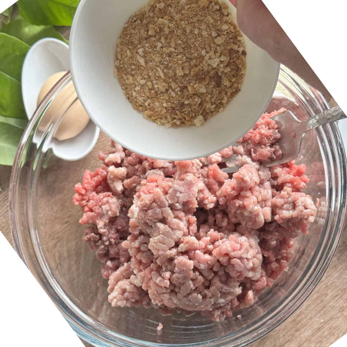 Adding breadcrumbs to the meat mixture.