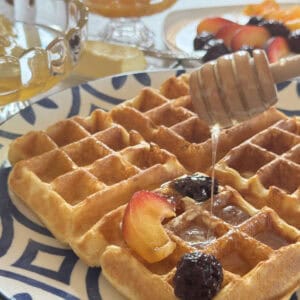 Close-up shot of a kefir waffle with berries and honey.
