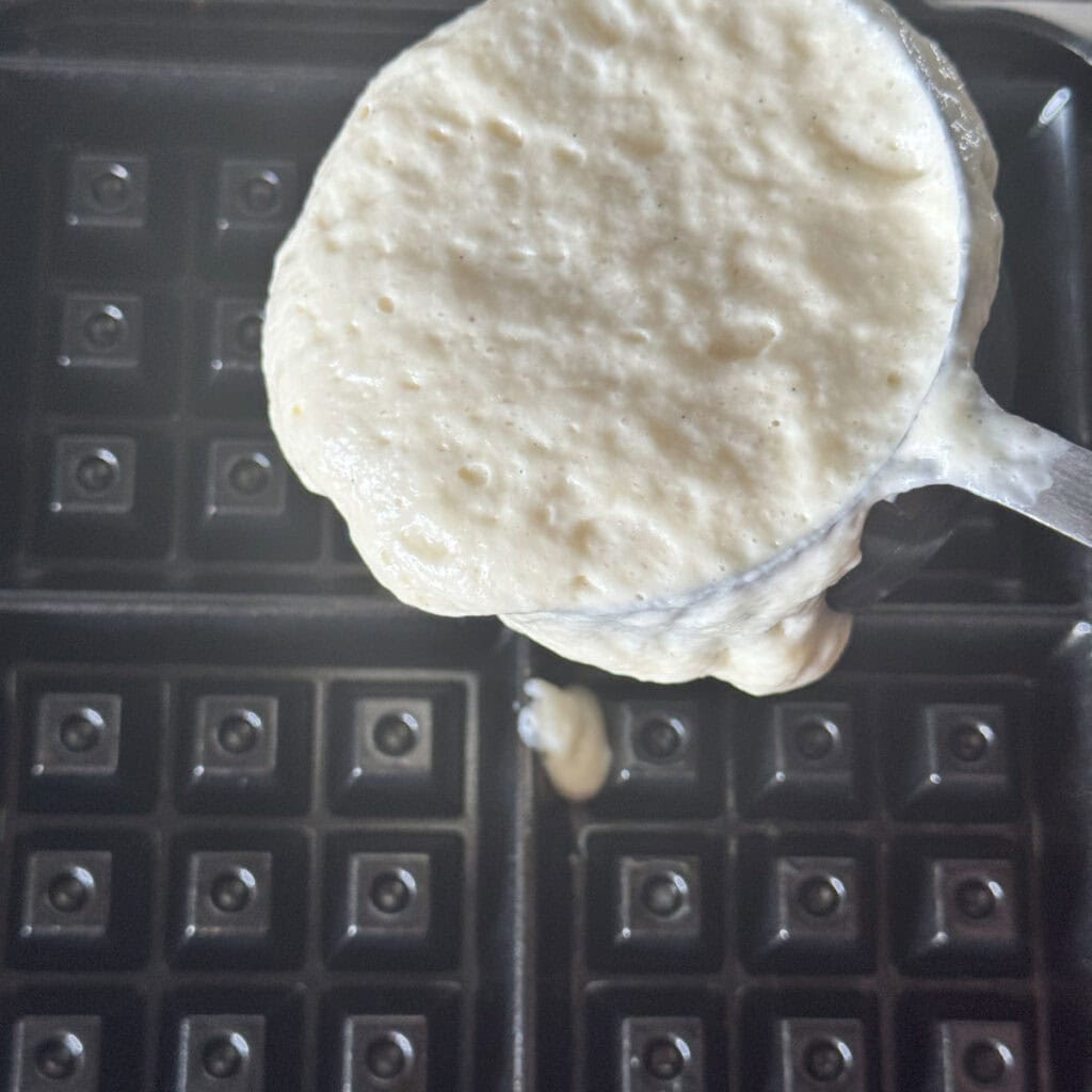 Cooking waffle in a waffle iron.