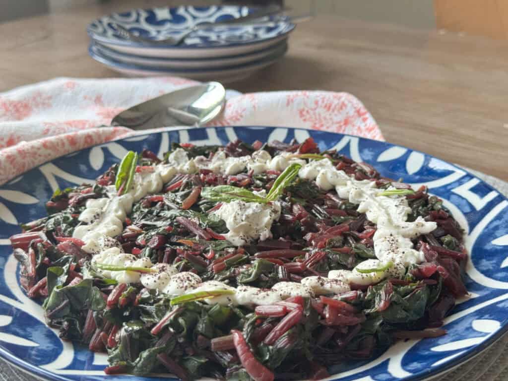 Sautéed beetroot greens with garlic yogurt sauce plated.