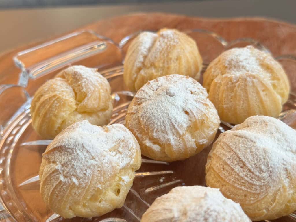 Cream puffs on a glass platter.