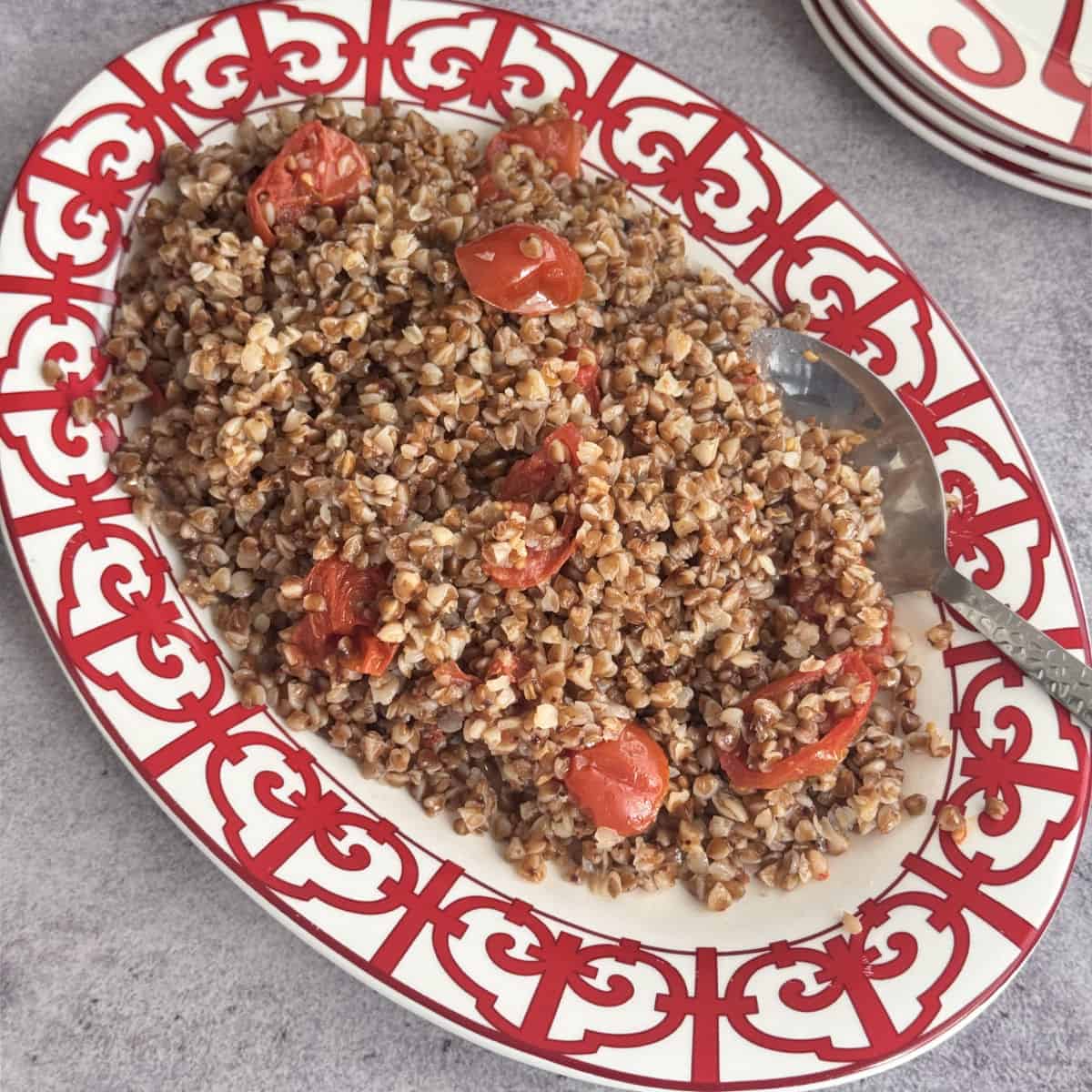Overhead shot of buckwheat pilaf on a red plate.