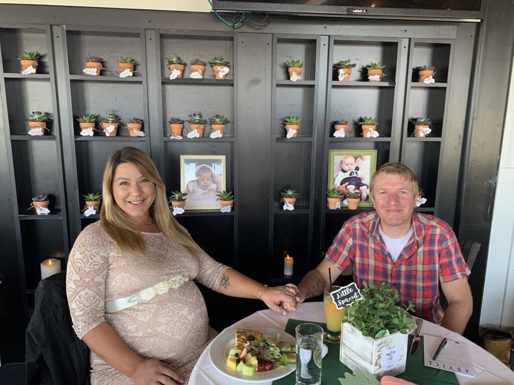 parents to be in front of baby shower favors